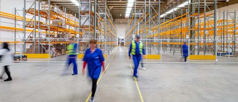 Trabalhadores com equipamentos de proteção em uma linha de produção.